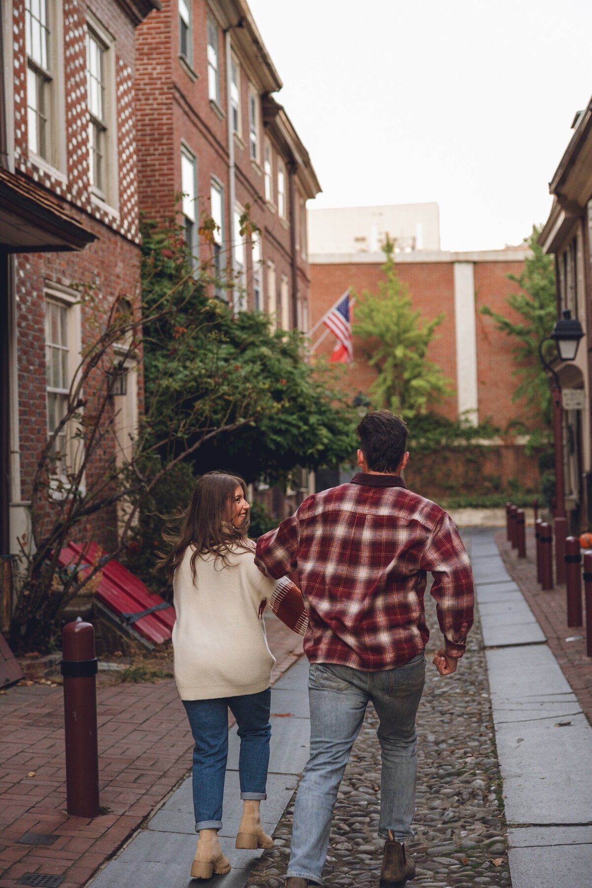 Couple walking hand-in-hand down historic Old City street.