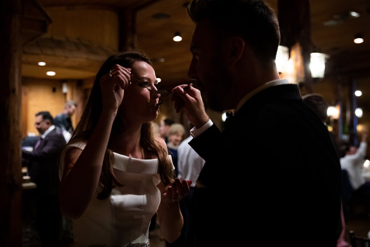 Bride and groom enjoy their first bites on cake at their wedding reception.