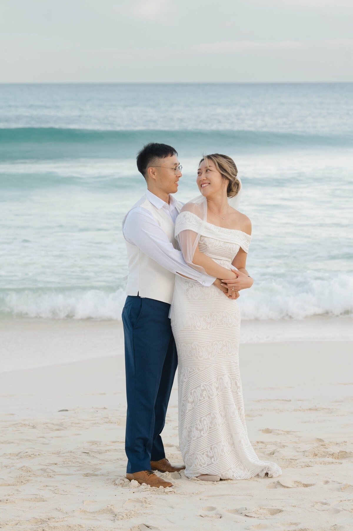 a bride and groom on the Beach at their wedding in Cancun