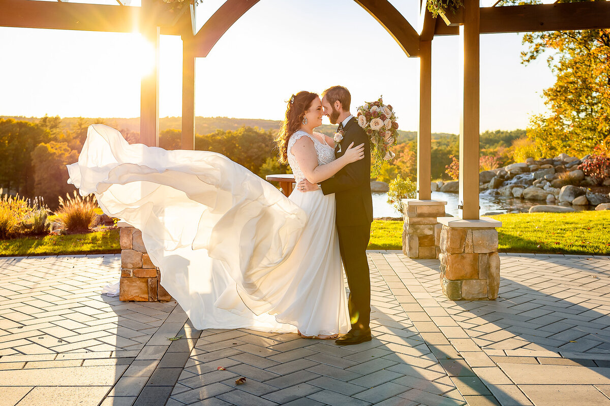 Bride and groom kissing at sunset with brides dress blowing in the wind at Pembroke Pines Country Club wedding by NH wedding Photographer Lisa Smith Photography