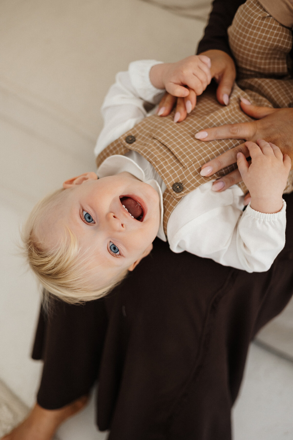 A little baby boy laughing at the camera during a milestone photoshoot in christchurch with lucy jane photography