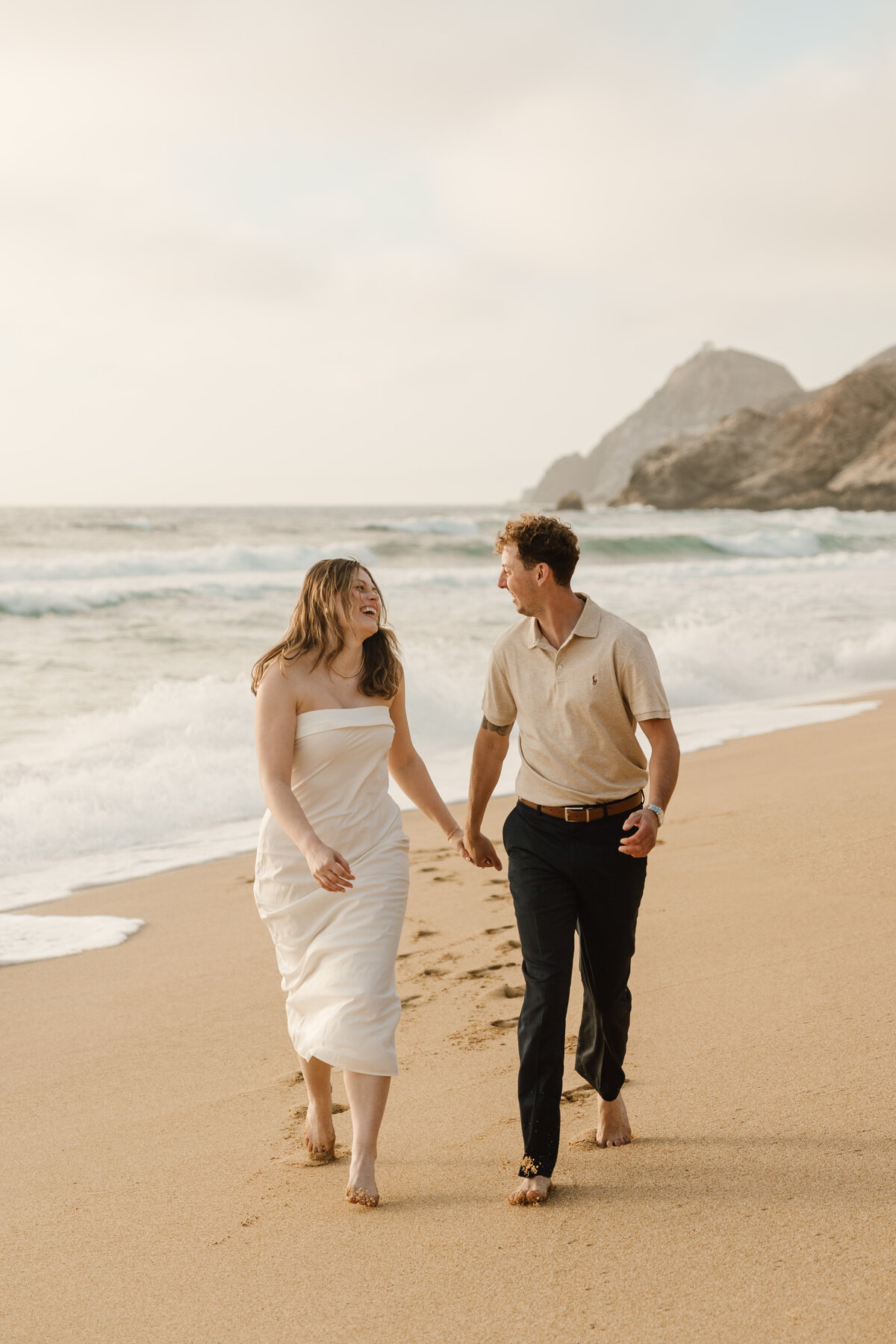 couple running on beach in half moon bay