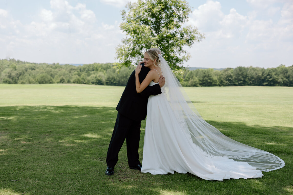 Bride and father of the bride first look; they share a hug