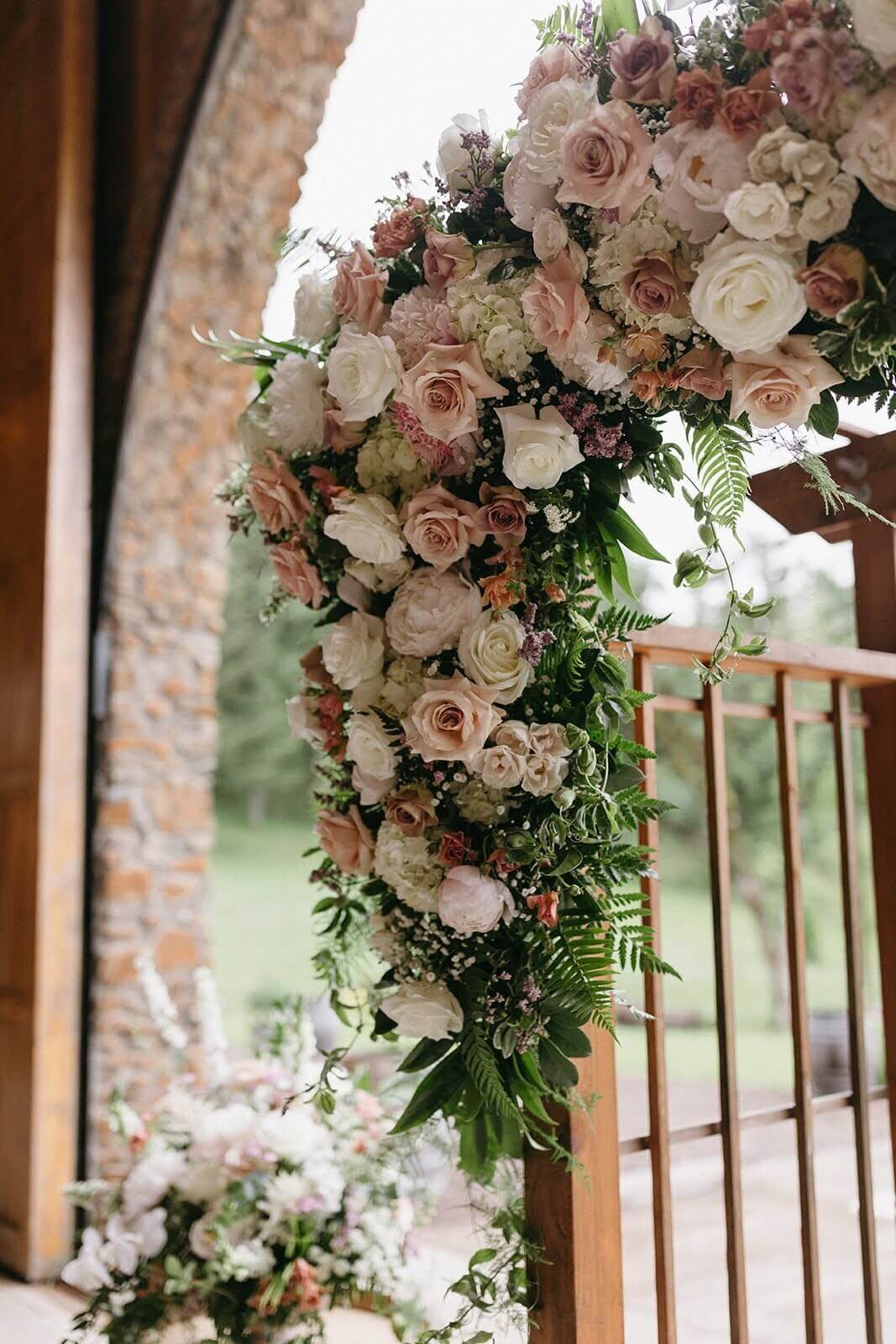A floral arch features a lush flowers installation in soft pastels by Eugene florist Flowers and Thyme.
