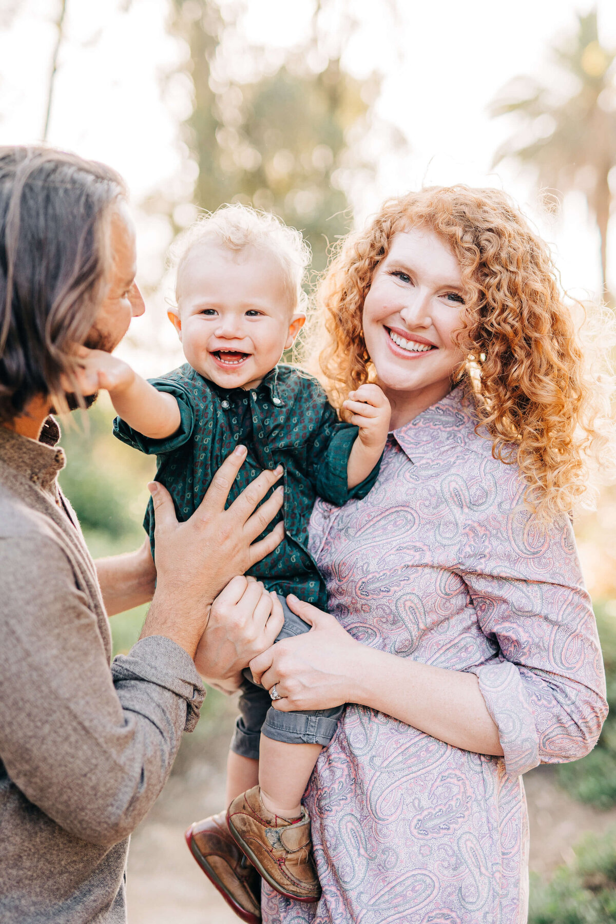 Baby is smiling and happy with his family during family photos