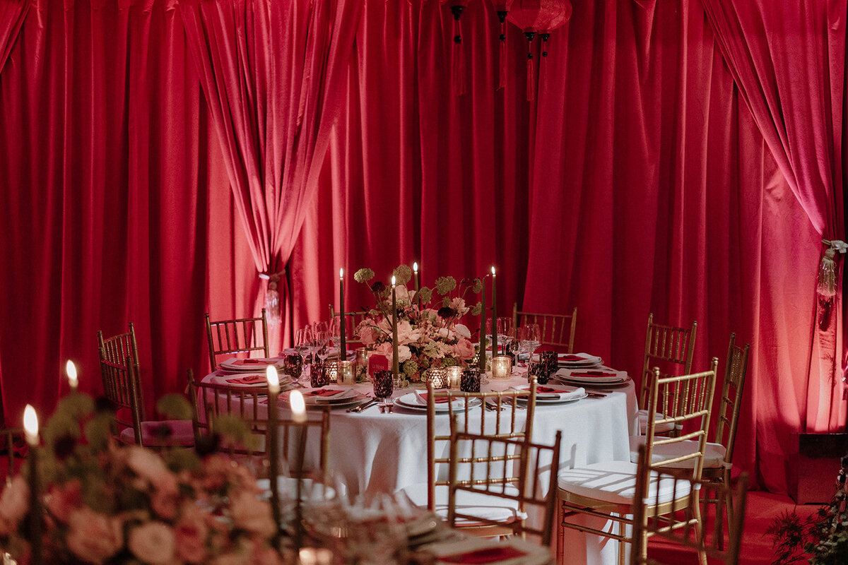 Chinese-inspired red wedding decor with luxurious draping and floral arrangements at Monkey Island Estate.