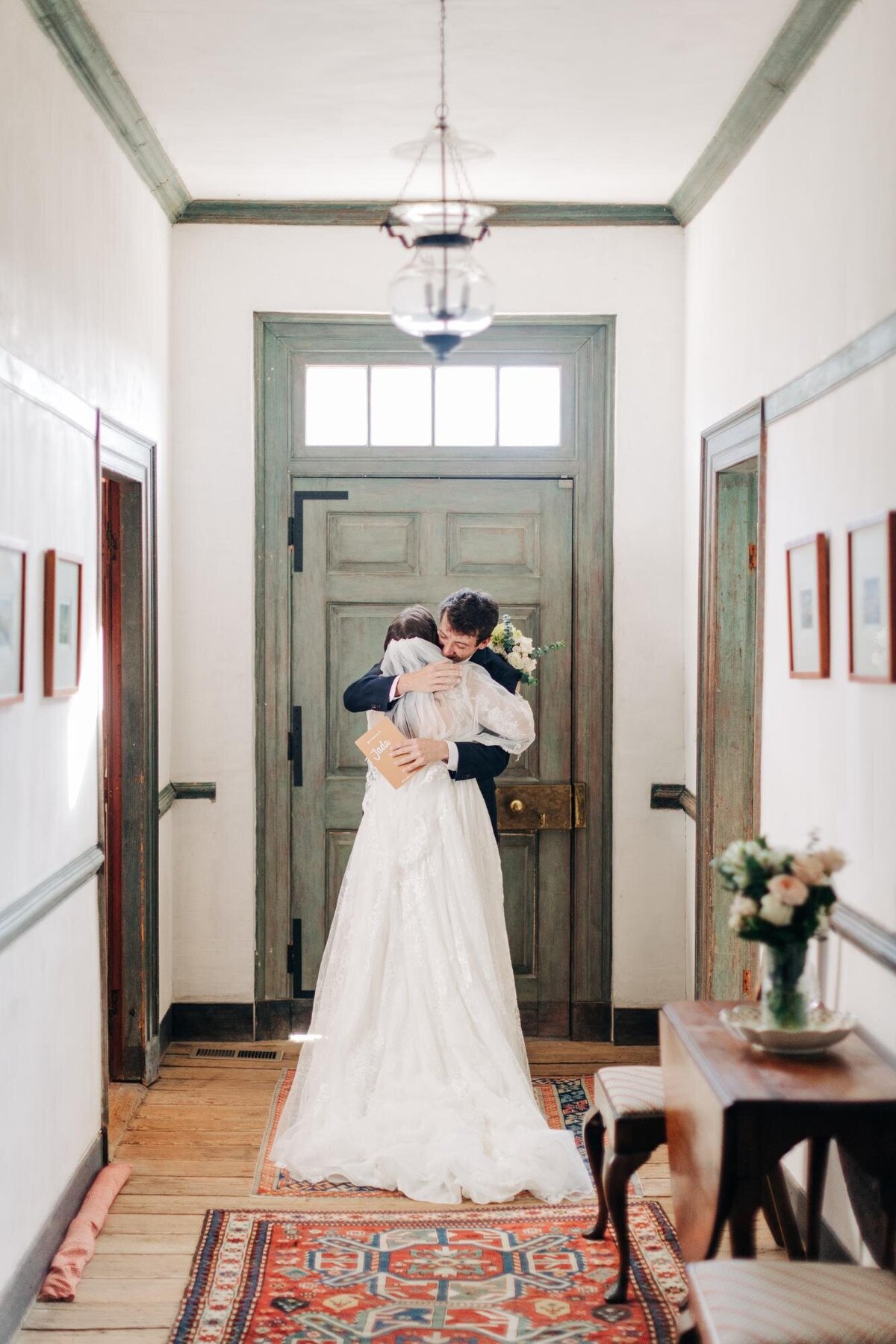 A bride and groom sharing an embrace in a vintage hallway with rustic decor.