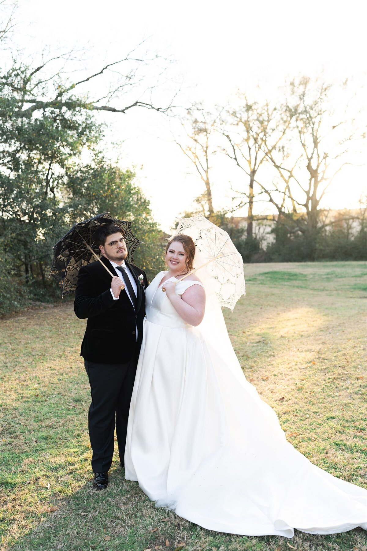 Bride and groom on their wedding day with umbrellas.