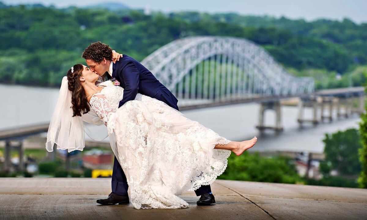Wedding couple dipping with Dubuque bridge in background