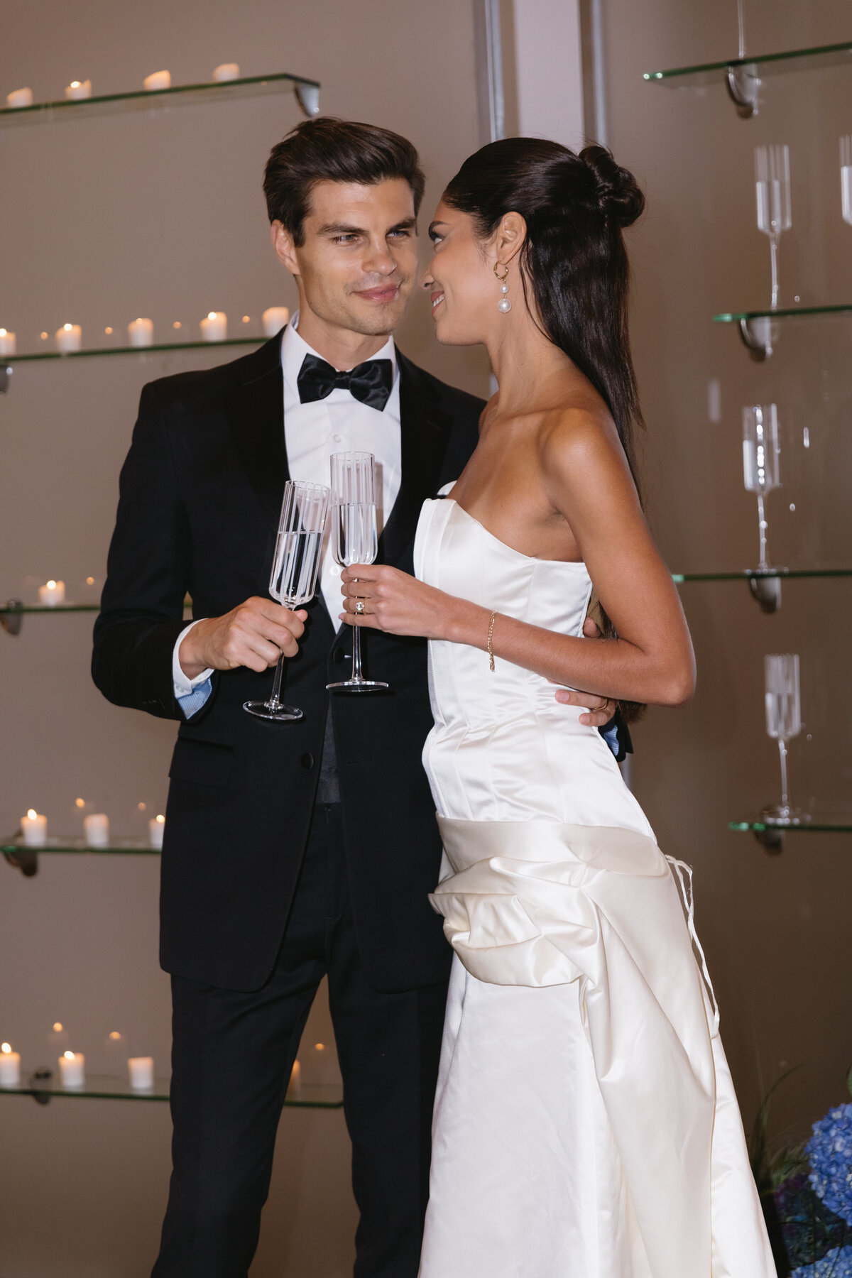 Chic wedding moment featuring a couple toasting with champagne in a modern venue.