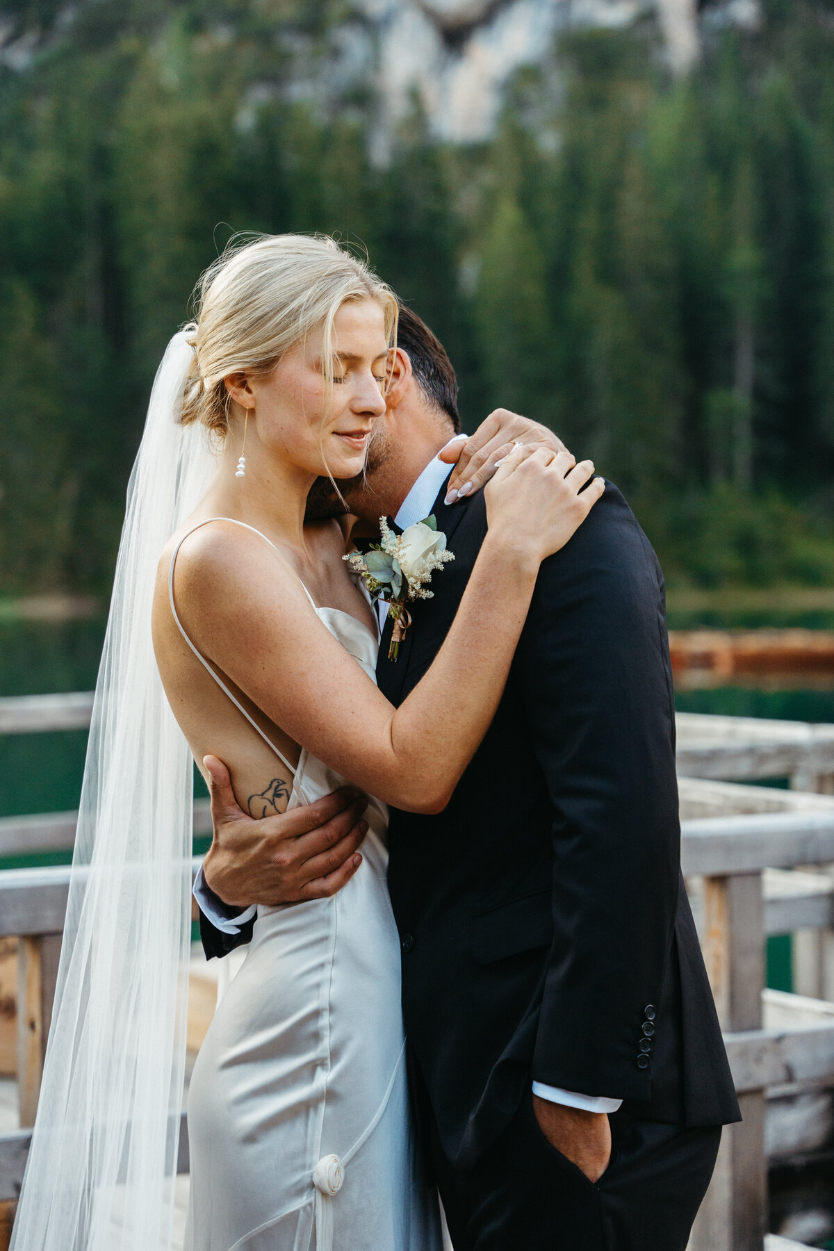 Bride closing eyes while hugging groom during quiet moment