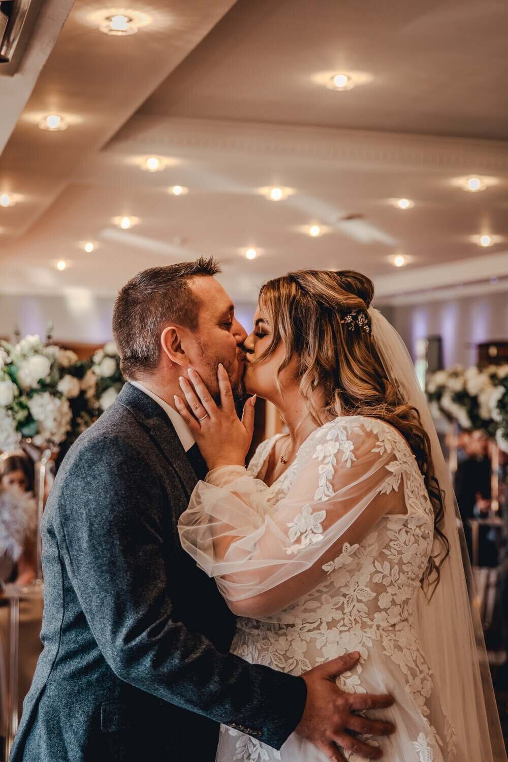 Bride and Groom kiss and embrace at reception