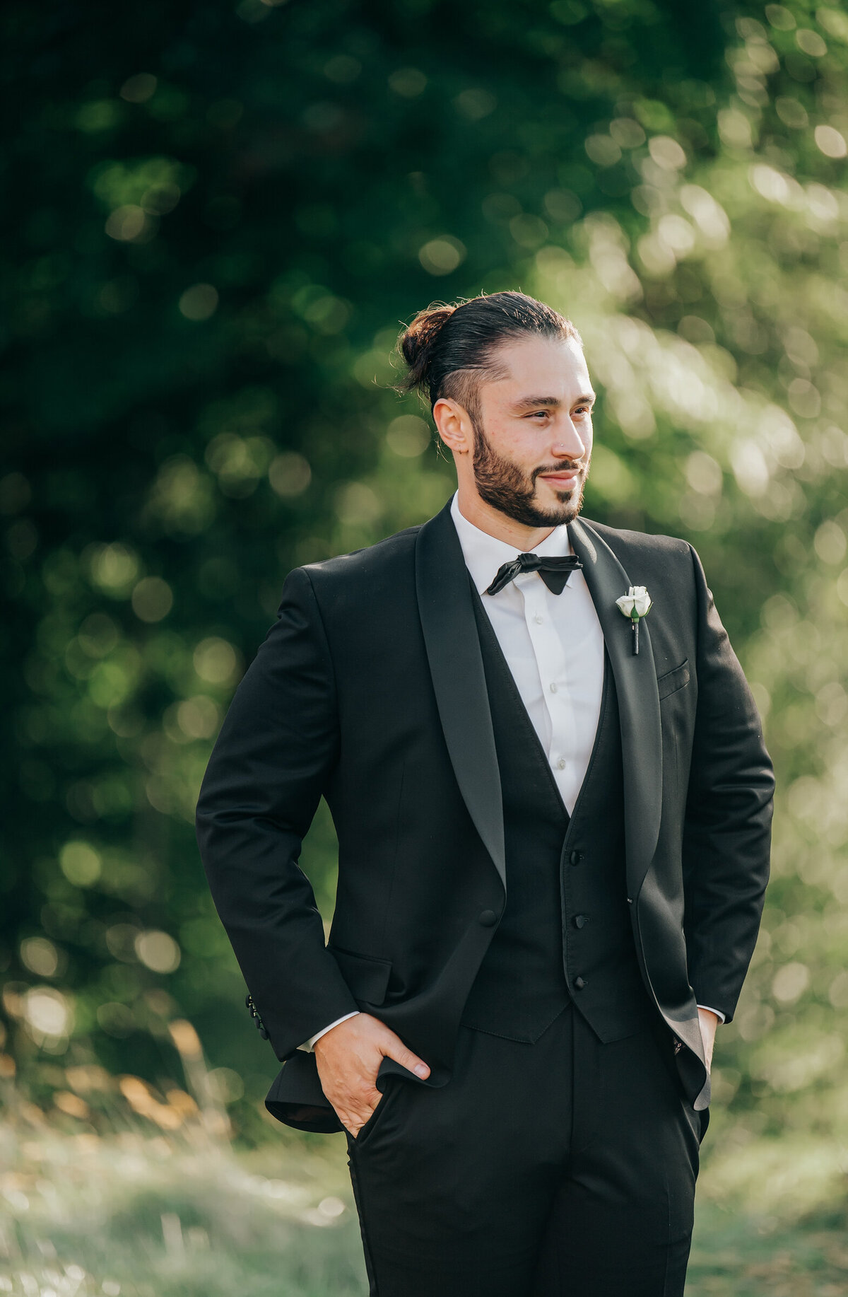 Groom posing for photos in his black tie attire on his Summer wedding day at the London Hunt Club