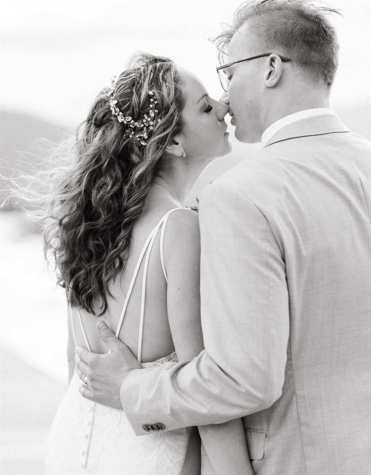 a black & white photo of a couple lovingly about to kiss