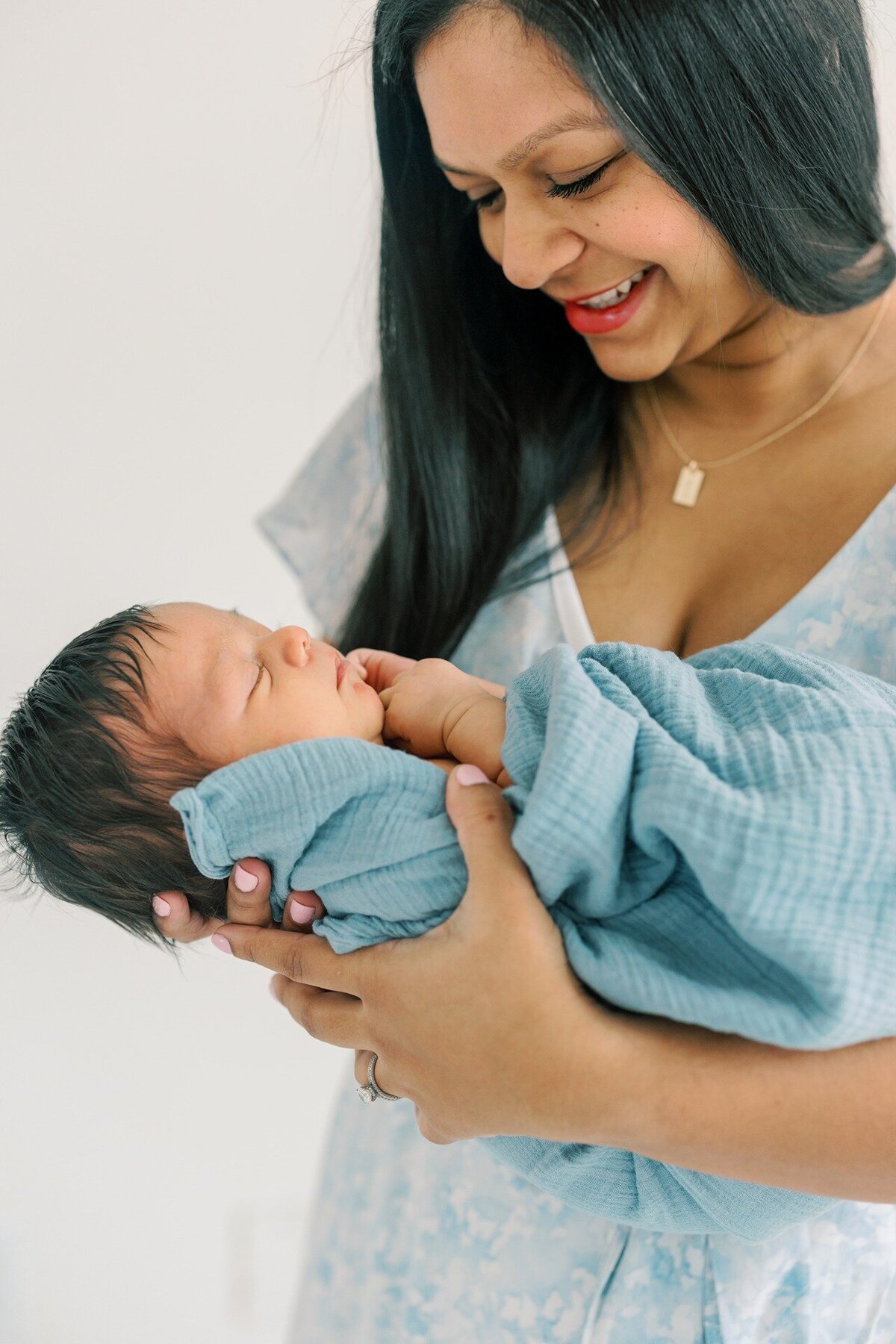 mom-holding-newborn-son-in-blue-swaddle