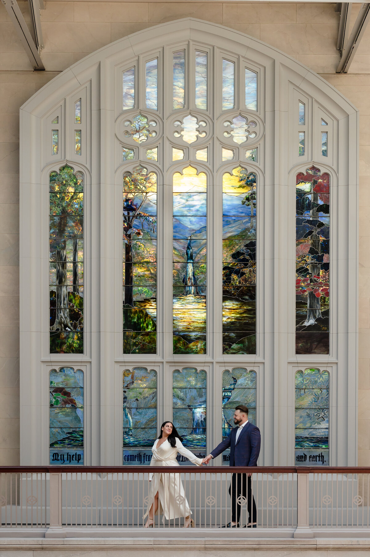 A couple walk in front of the Tiffany glass at the Chicago Art Institute 