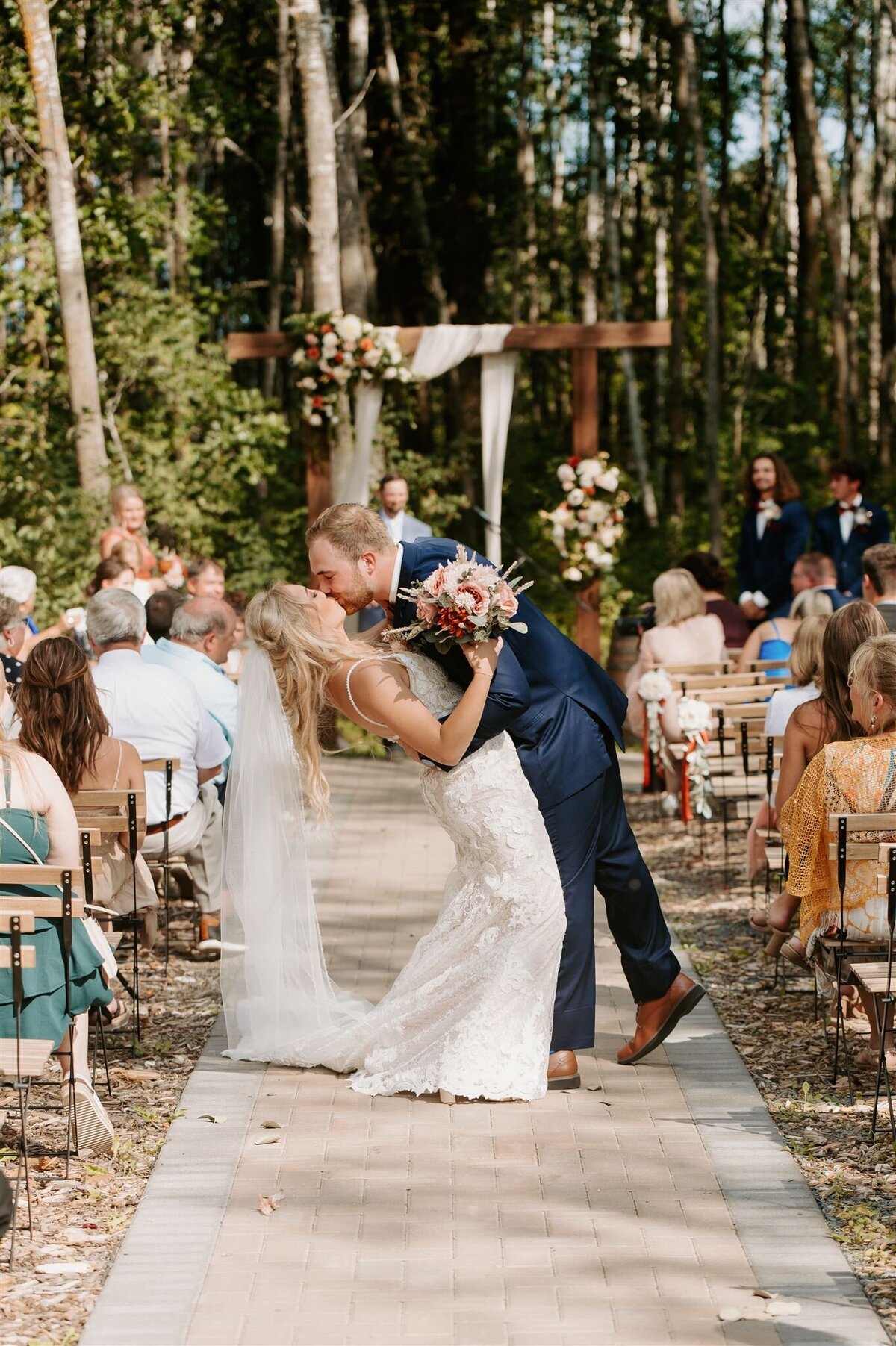 Bride and groom dip during first kiss down the aisle at Bluebelle