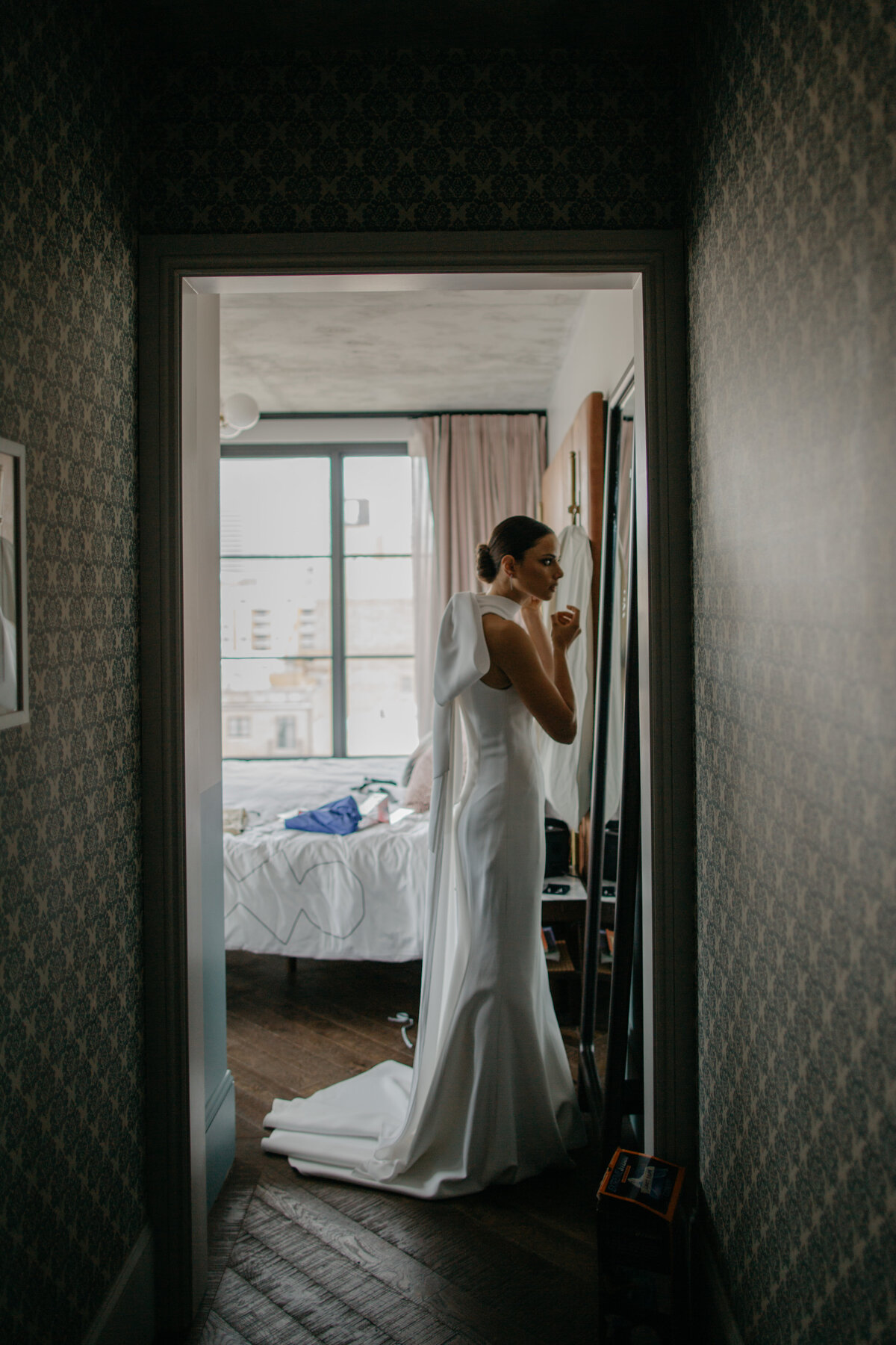 Bride looking into mirror while getting ready