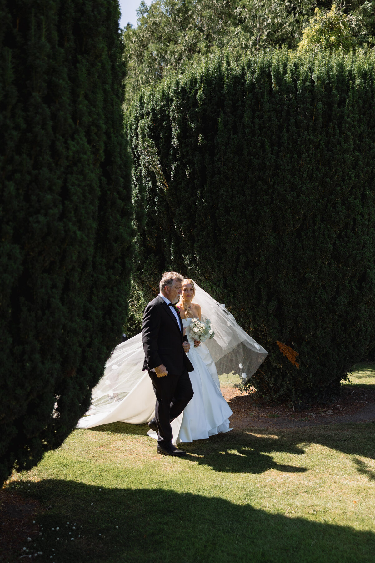 Bride approaches wedding ceremony with father at Luttrellstown Castle, Ireland