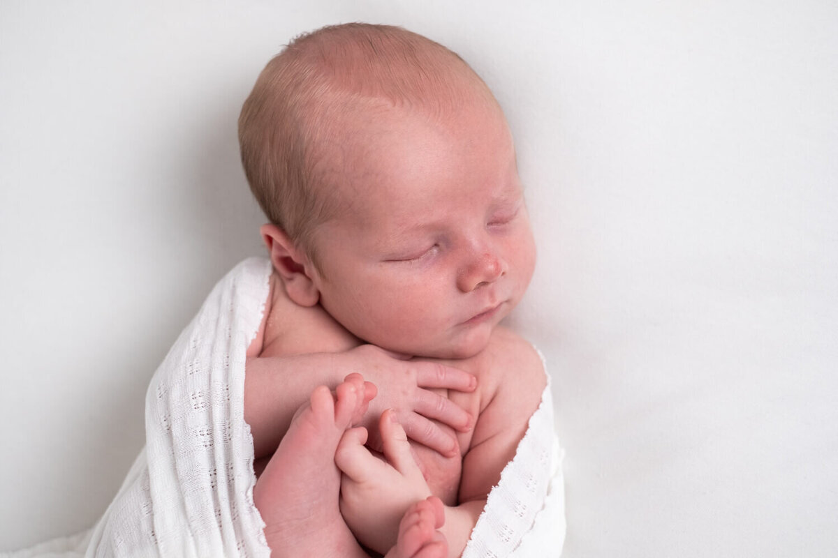 De newborn shoot bij je thuis met effen achtergronden en zachte tinten brengen je baby op de voorgrond, voor foto’s die je voor altijd wilt bewaren.