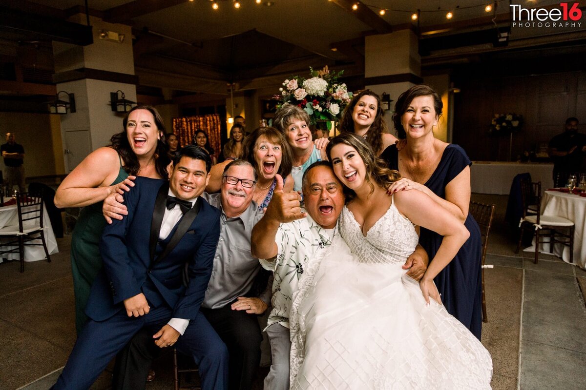Bride and Groom pose with wedding guests as they table hop
