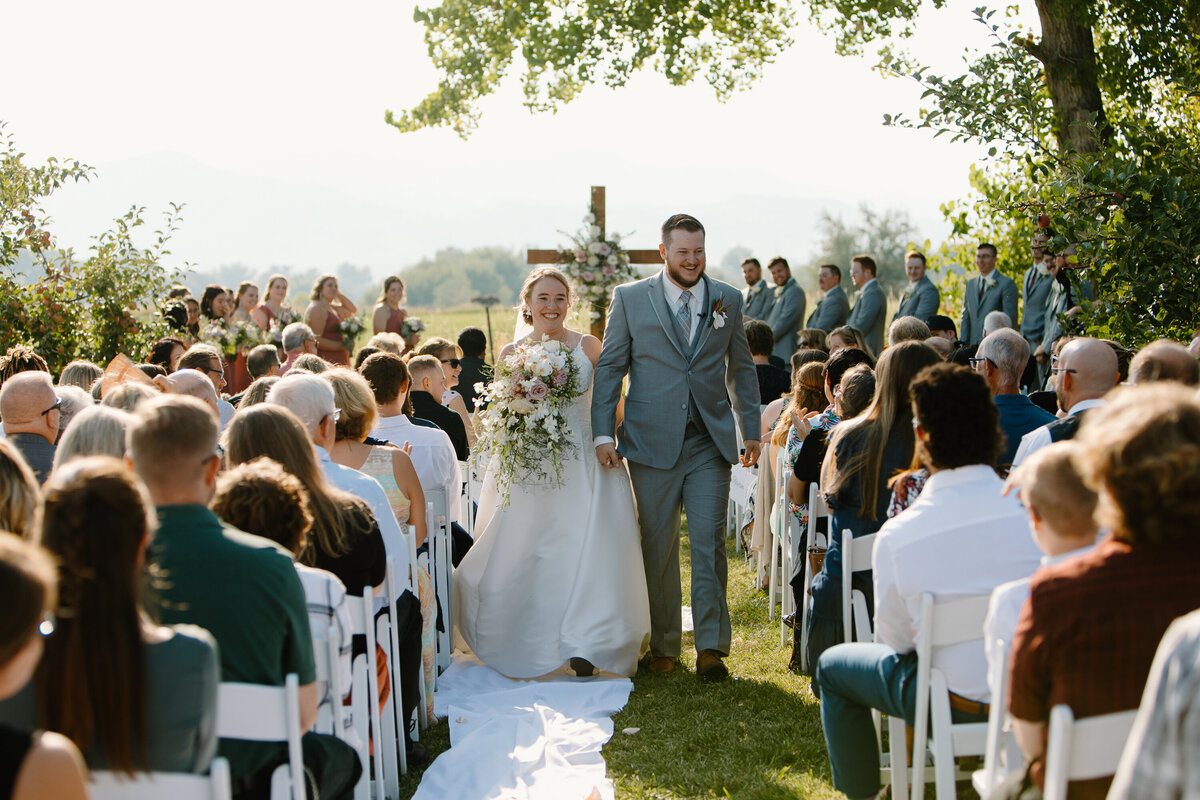 A newlywed couple walks down the aisle after their wedding ceremony in Fort Collins, Colorado.