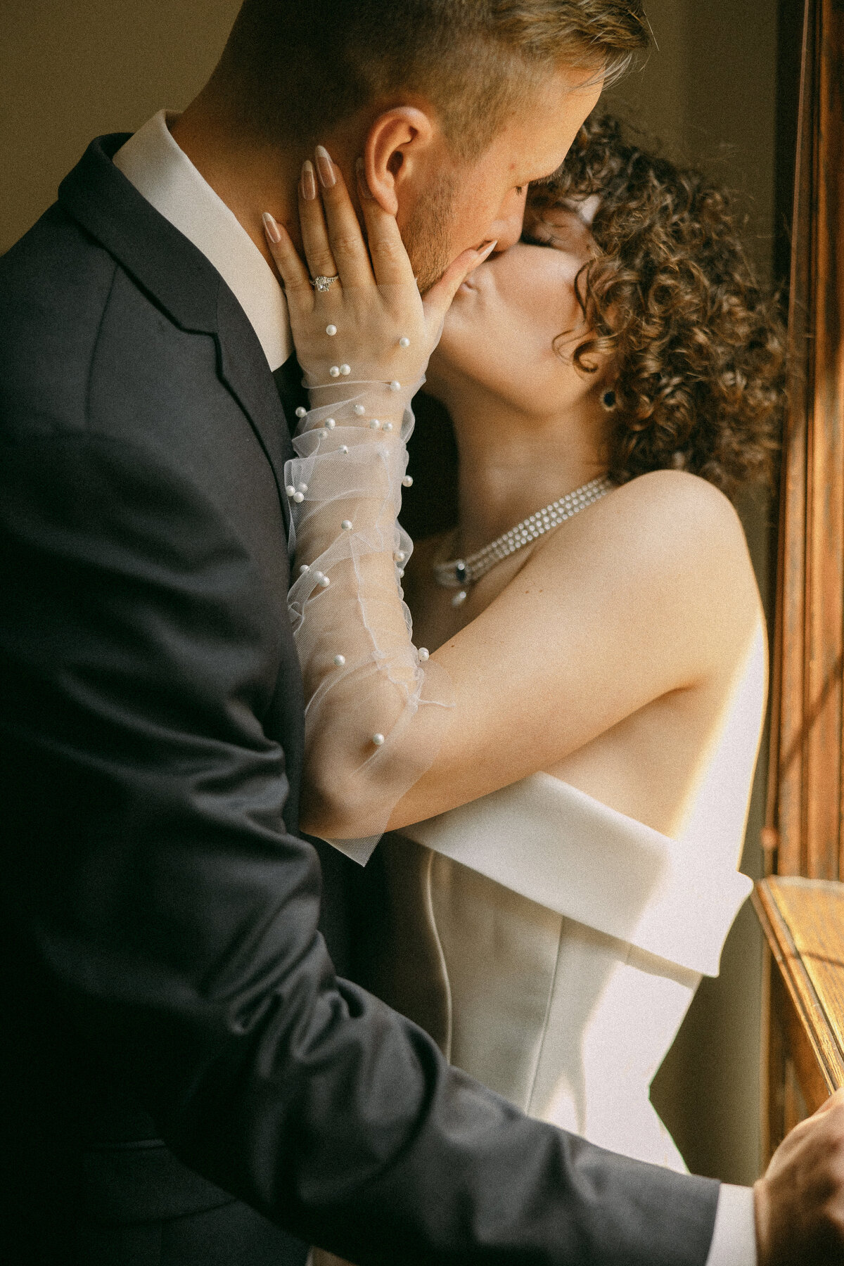 a close up photo of a groom and bride kissing