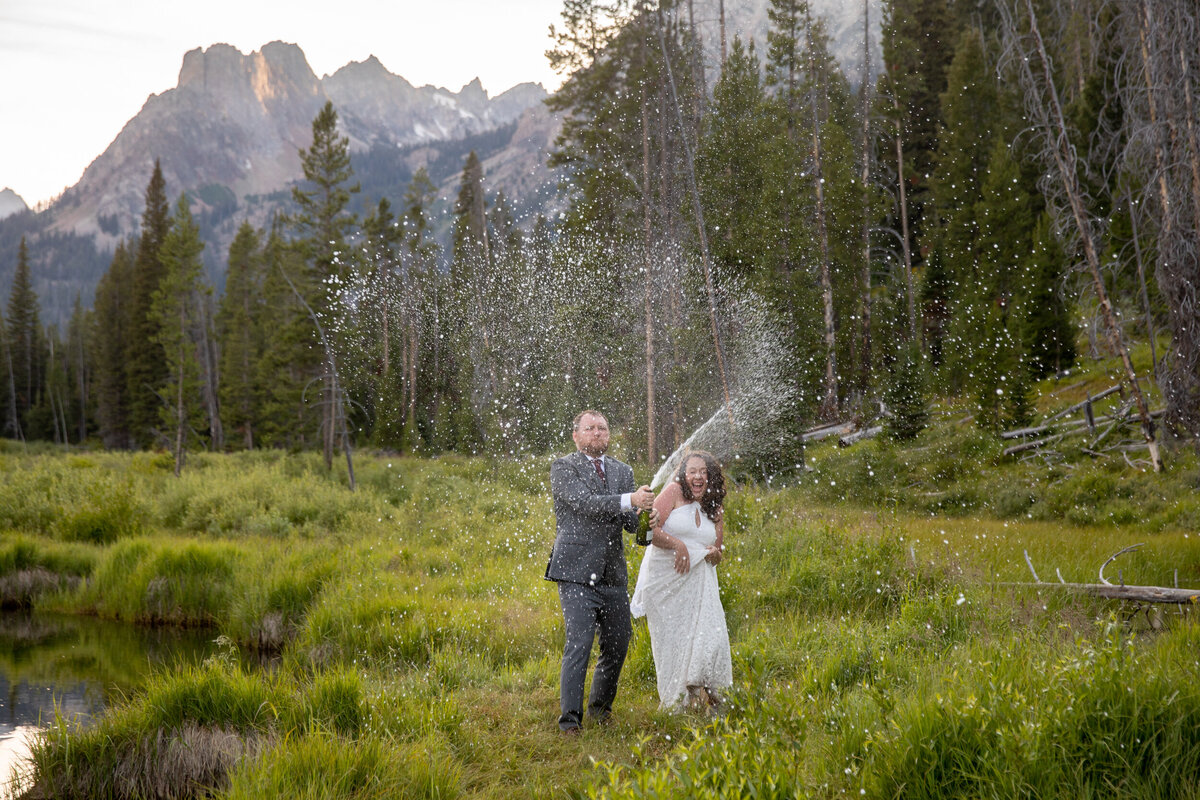 A groom sprays champagne at his Idaho elopement photographer.