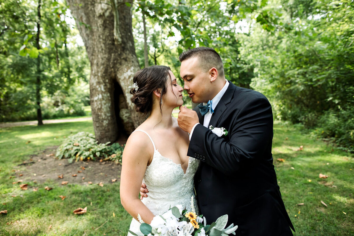 Bride and groom kissing in front of the Sycamore tree