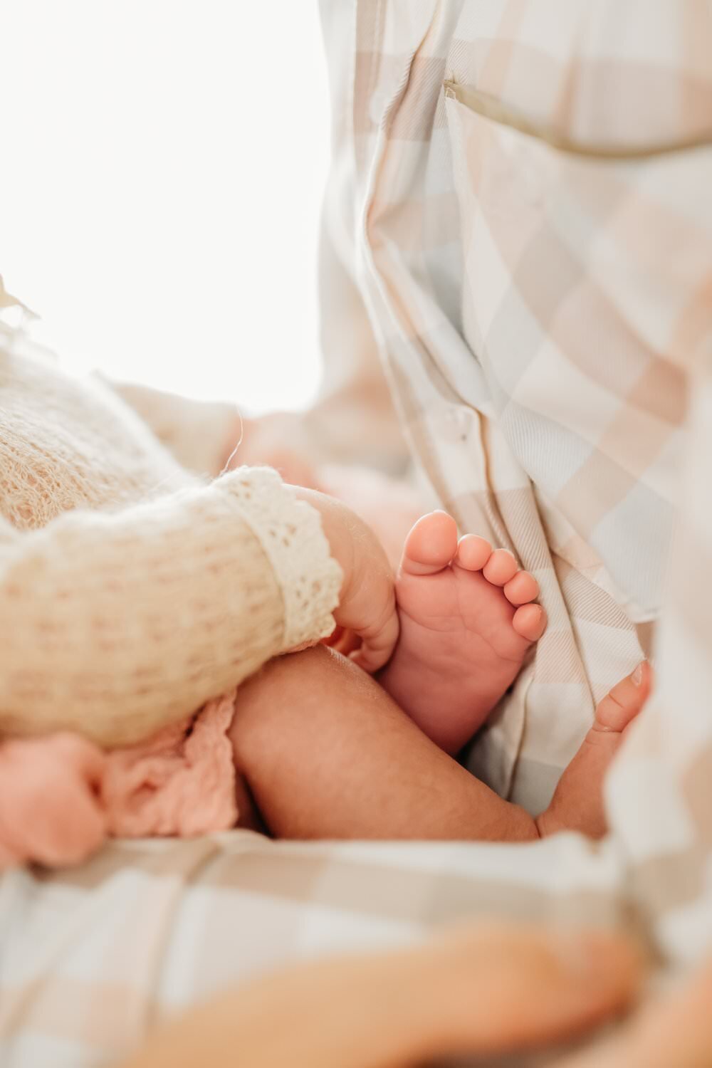close up of newborn toes against dads chest