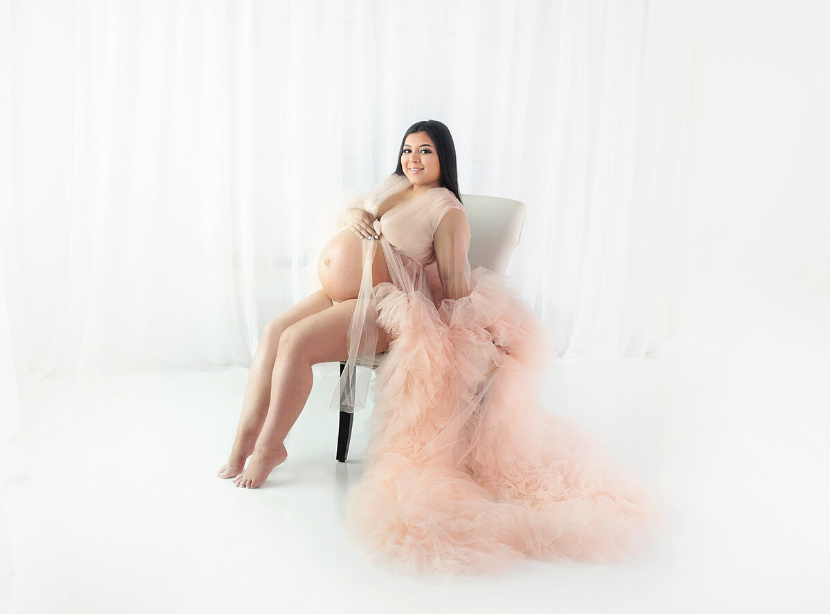 Women wearing peach gown during maternity photoshoot in Franklin Tennessee photography studio