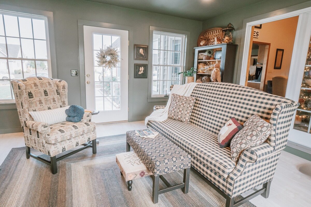 Early American textiles covered sofa bench and wingback chairs along with ottomans