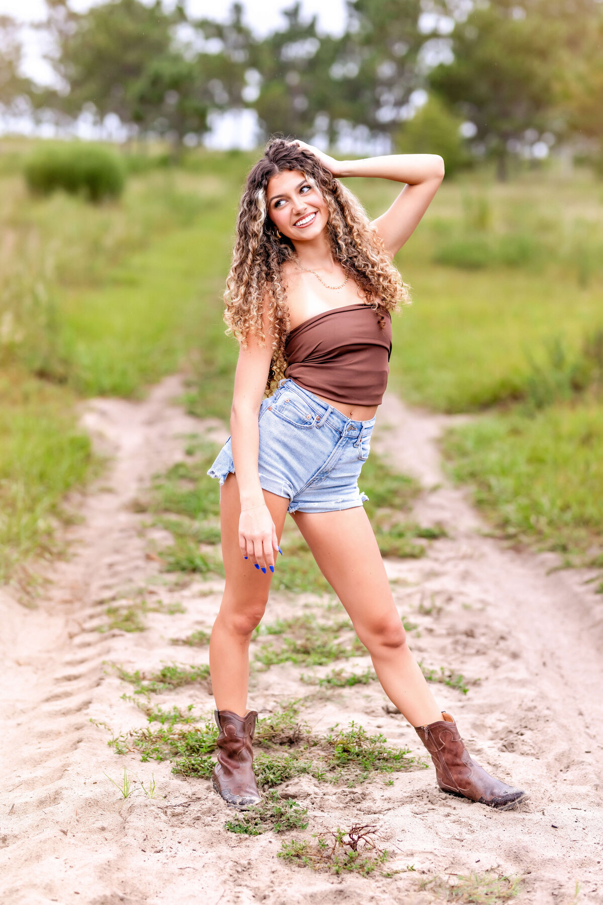 Confident senior girl striking a wide-stance pose while looking away during Orlando senior photos.