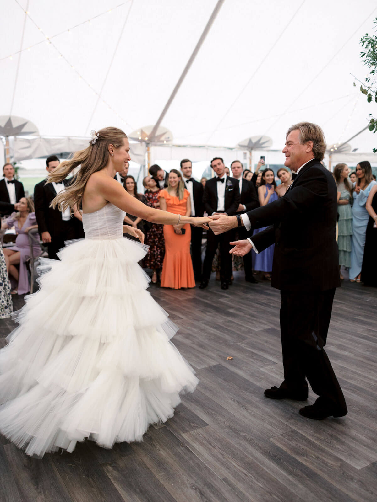 The bride is happily dancing with her father at the venue as guests cheer at The Ausable Club, NY. Image by Jenny Fu Studio