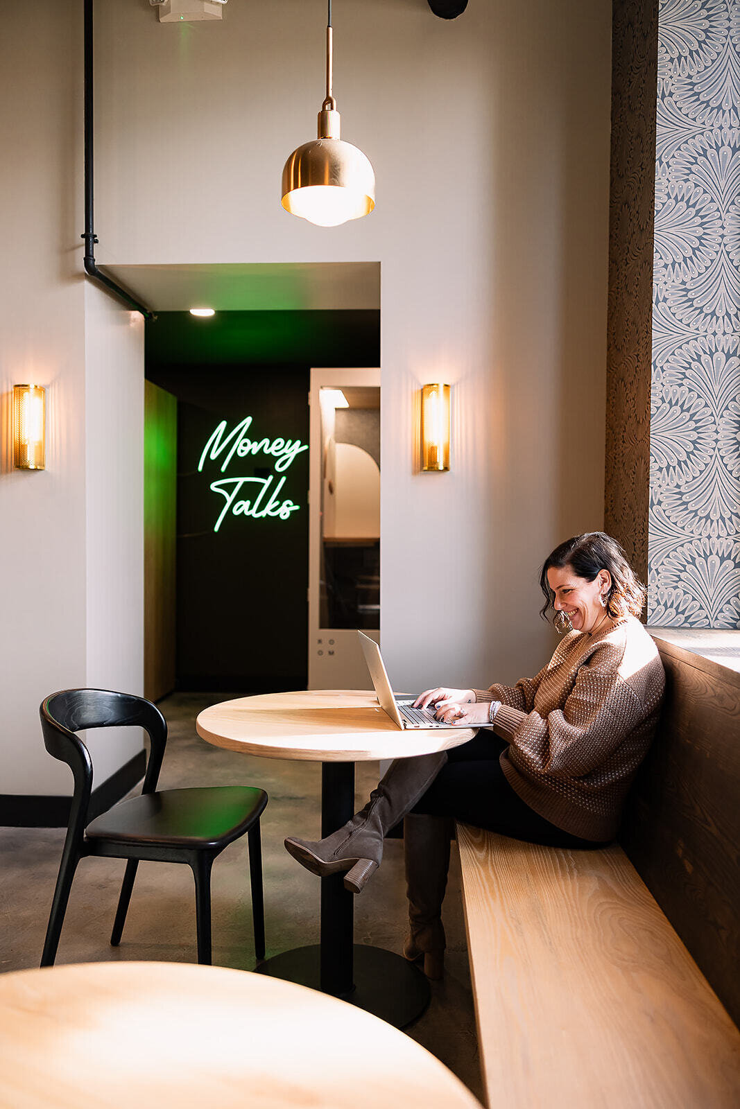 Woman sitting in a restaurant with a computer while typing