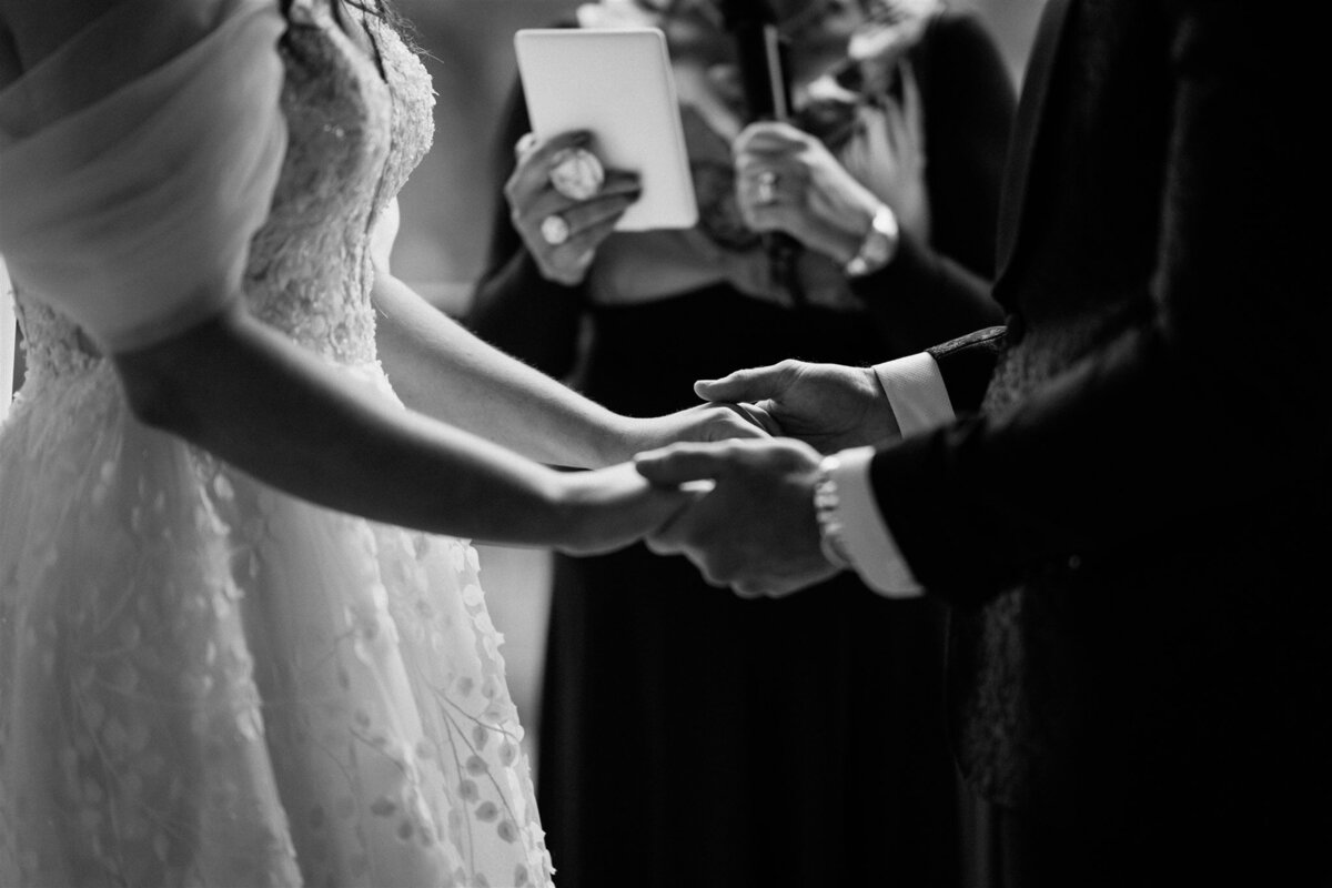 A couple stands lovingly at their ceremony, exchanging vows with heartfelt emotion.