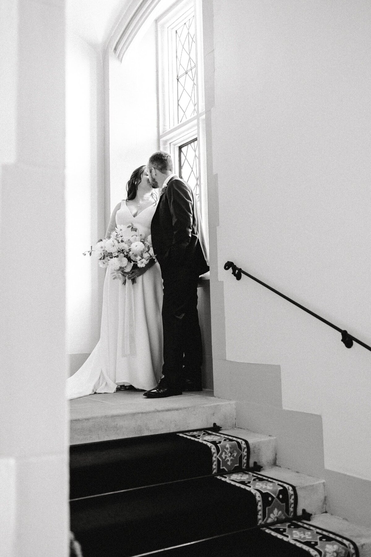 Bride and groom kiss in front of window at Branch Museum Richmond wedding