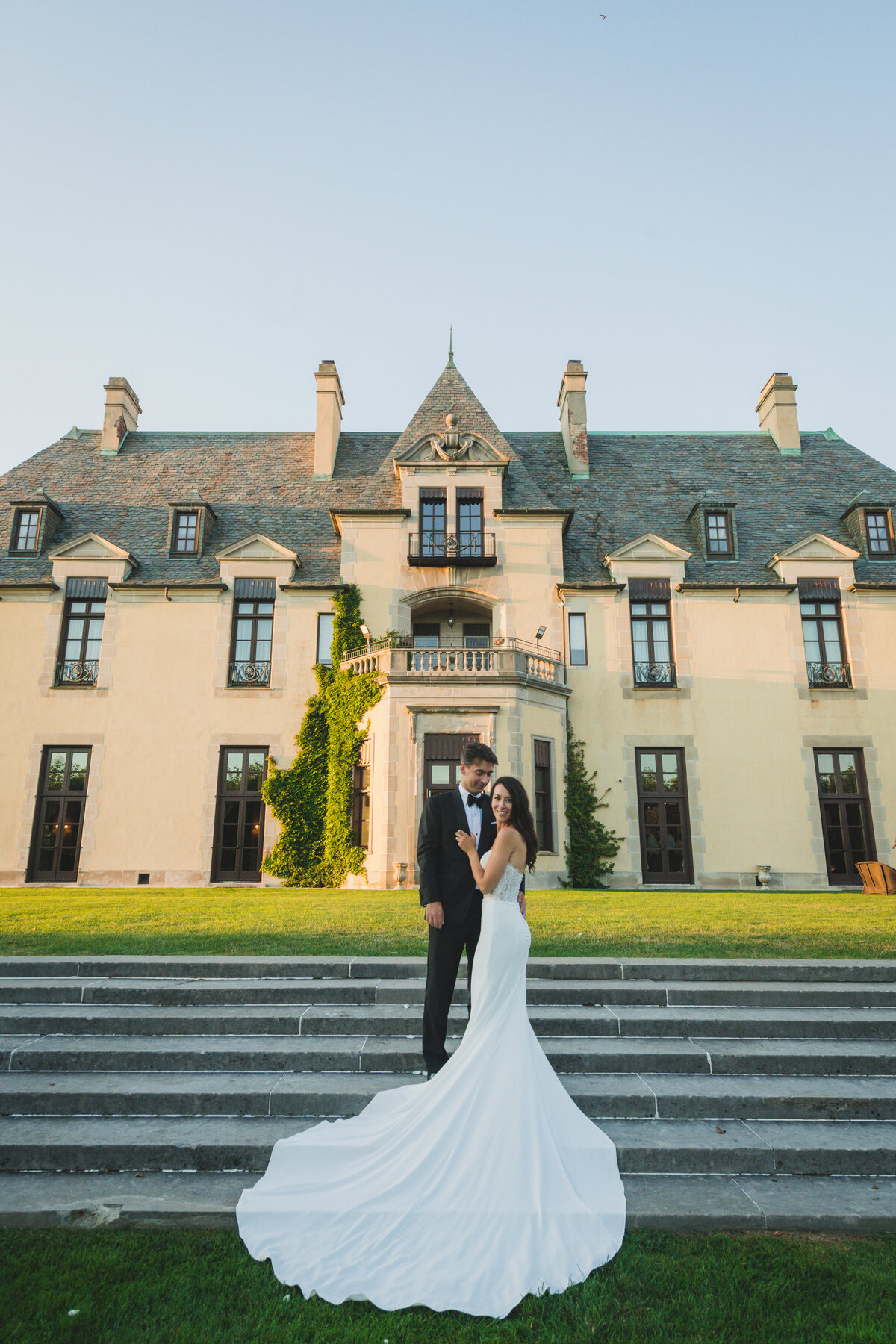 bride and groom posing outside Oheka Castle