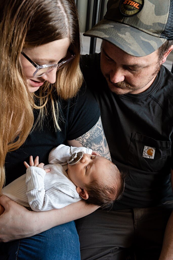 newborn boy with parents looking at him