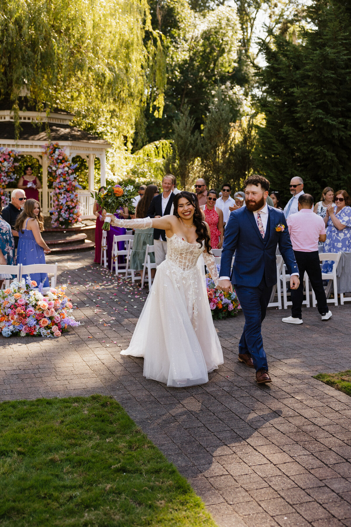 Bride and groom walk arm-in-arm down the aisle after saying “I do.”