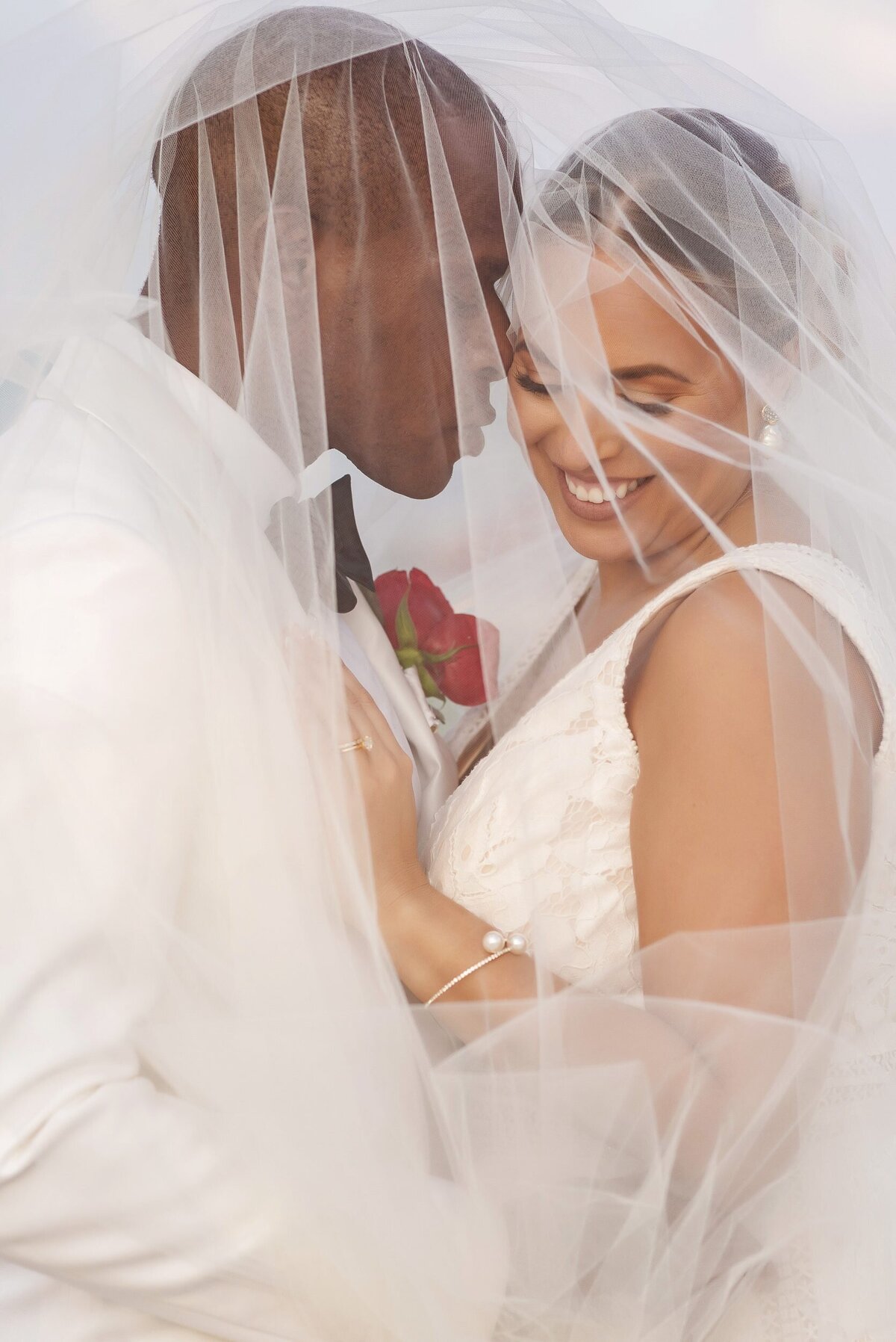 Close up of groom kissing bride under veil at wedding in Riviera Maya