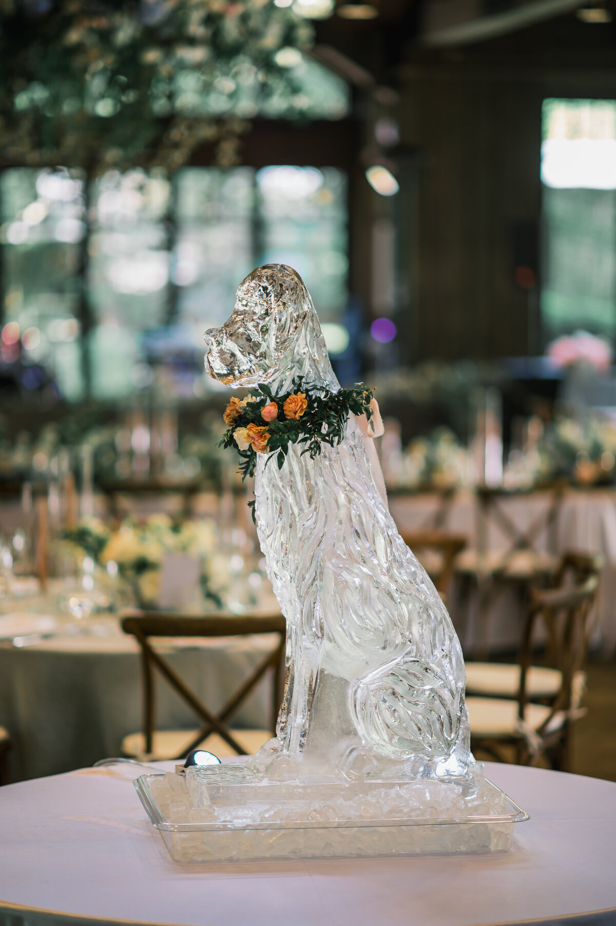 Elegant dog ice sculpture displayed in front of a lush floral arch during a wedding reception at Old Edwards Inn in Highlands, North Carolina.