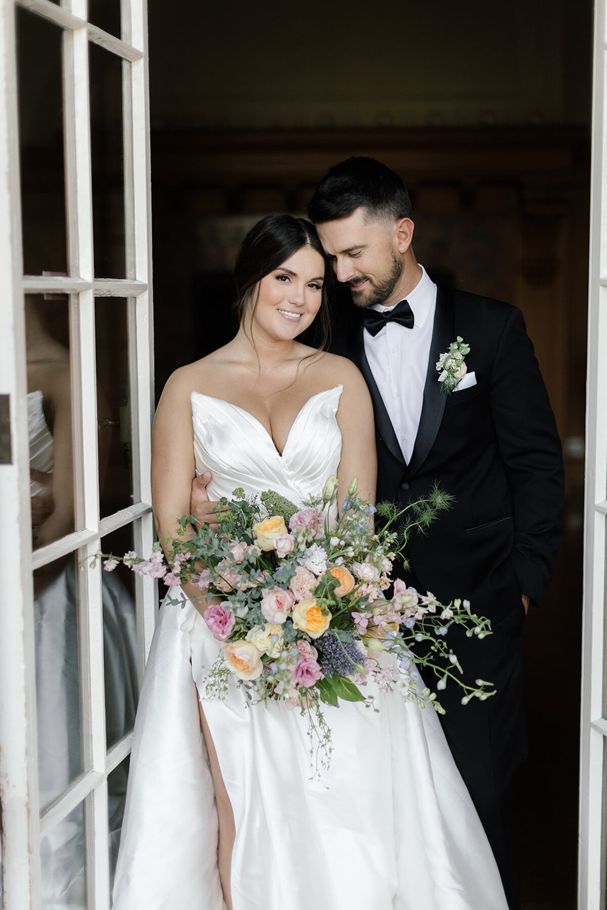 Bride and groom embracing with large bouquet at villa montalvo