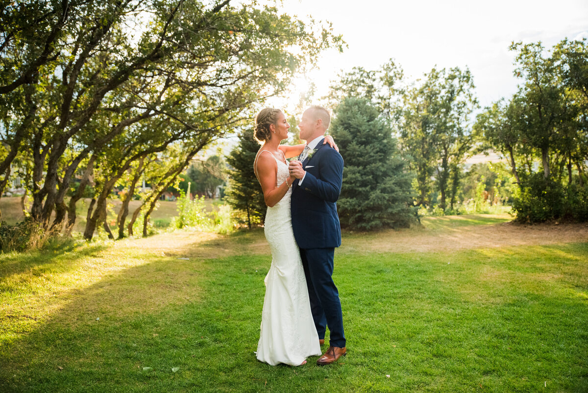 A bride and groom share a "fake" first dance in a field at The Oaks at Plum Creek at golden hour.