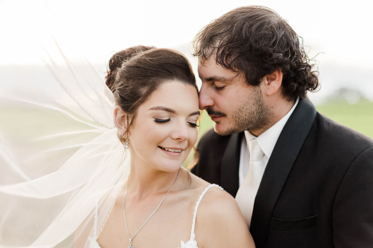 groom nuzzles into his bride for a sweet portrait on their mackay wedding day
