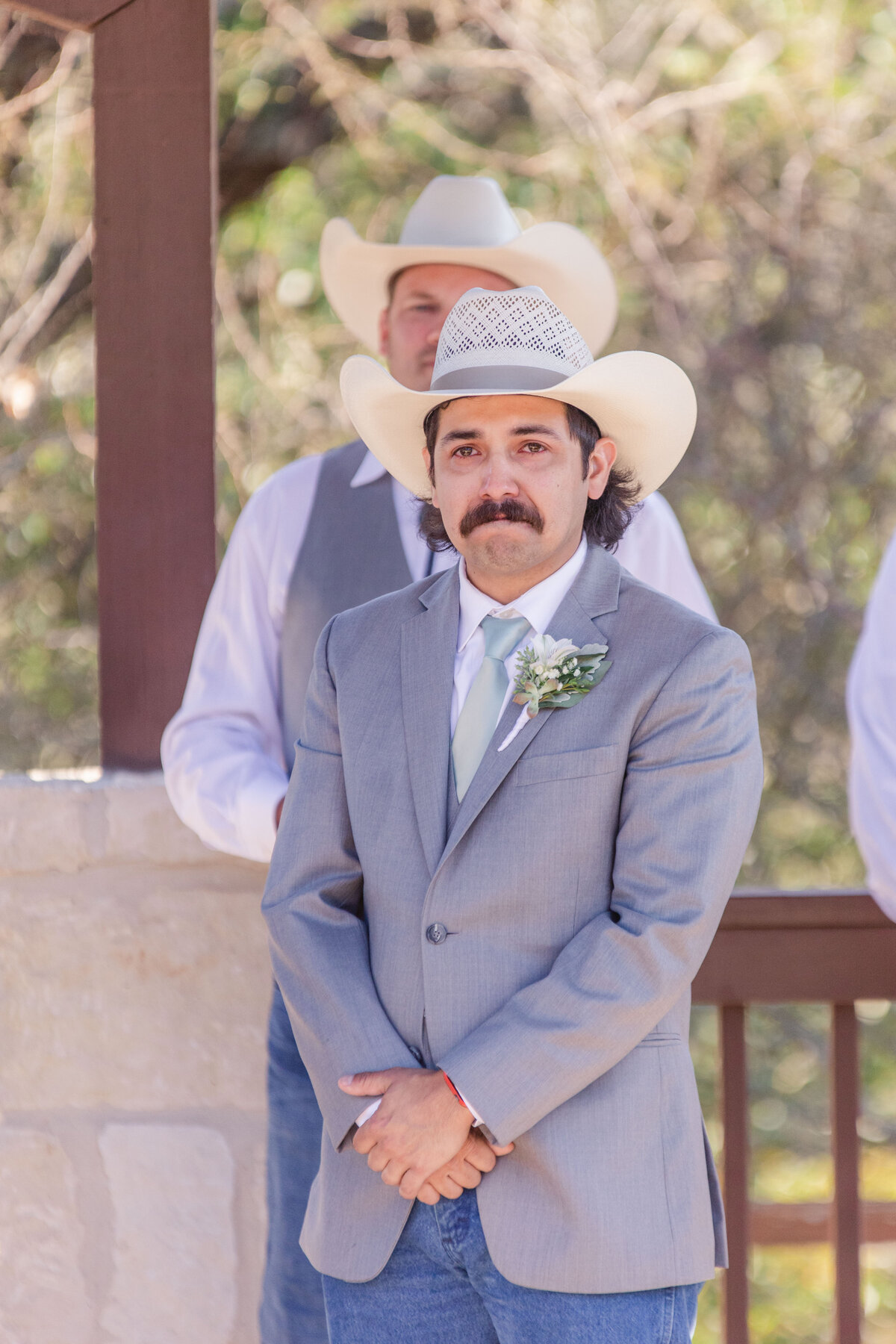 groom with cowboy hat and mustache is brought to tears at Boerne Texas wedding