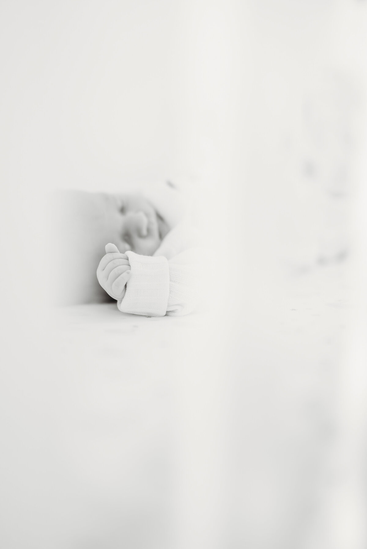 Minimalist close-up of a newborn’s hand during a modern Kansas City newborn photography session.