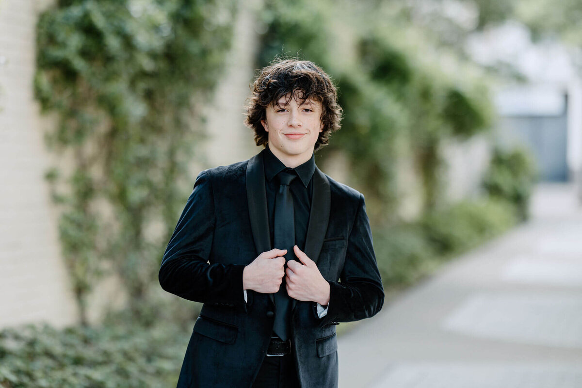 Senior portrait of Longview Lobo 2023 graduate in black suit and black tie in downtown Longview, TX