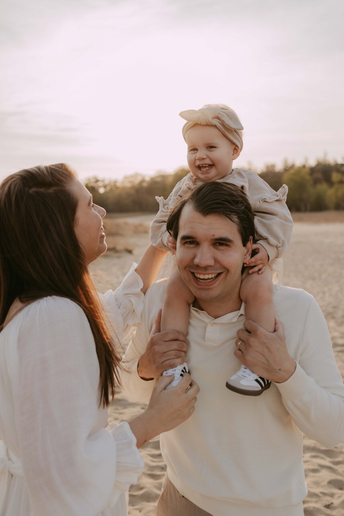 kindje zit bij papa op zijn schouders