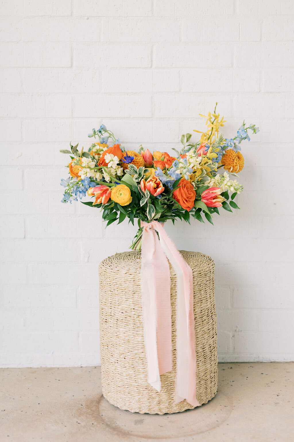 colorful bridal bouquet sitting on a wicker basket